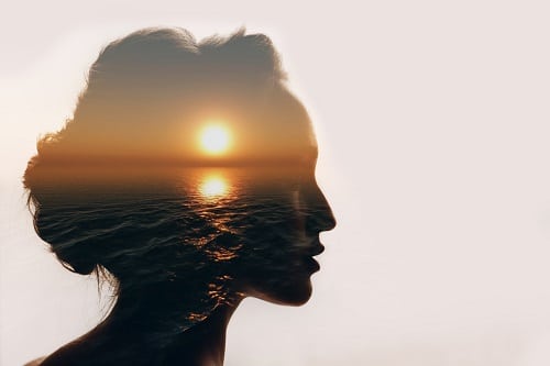 Psychologisches Konzept. Sonnenaufgang und Silhouette einer Frau.