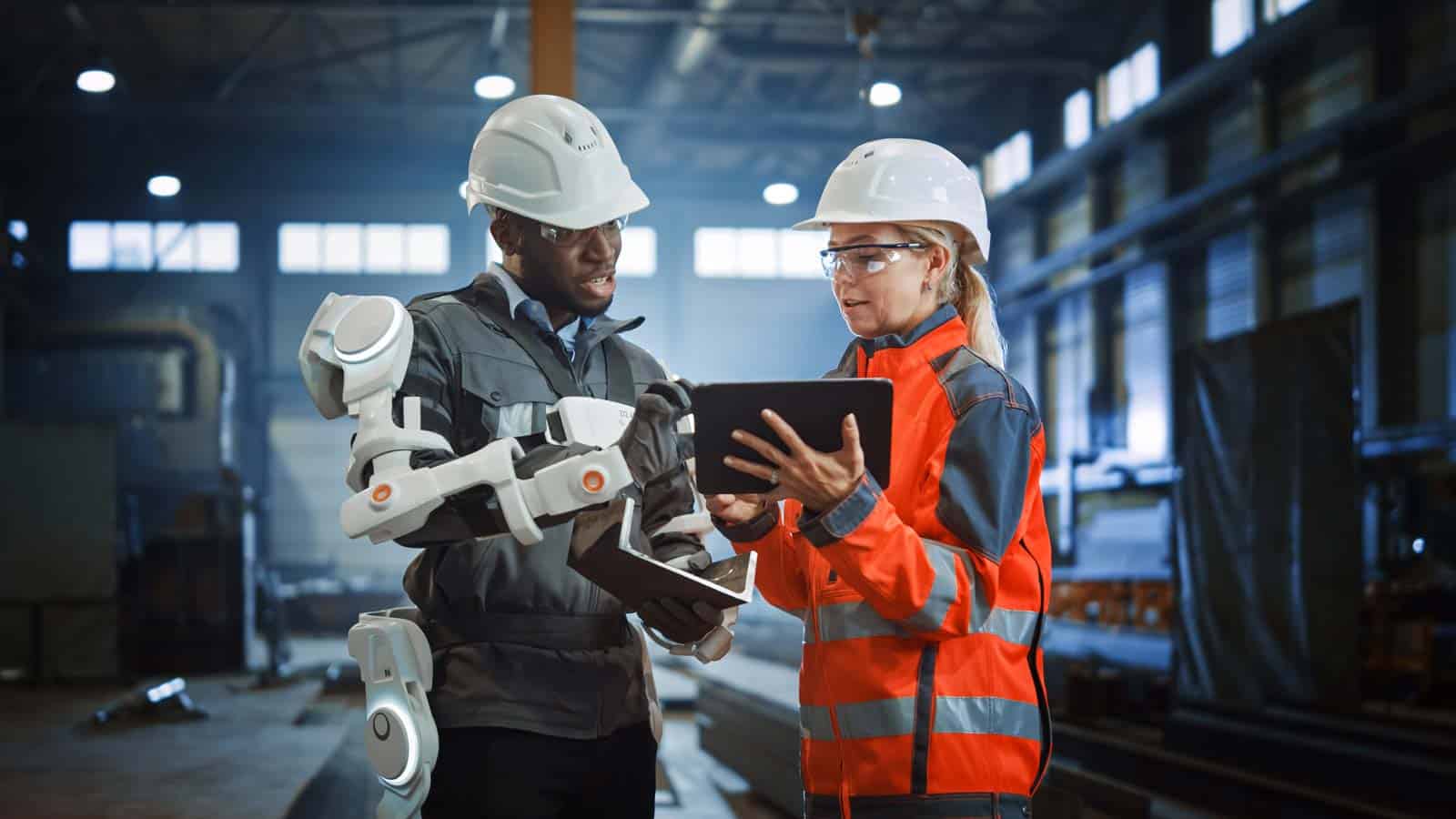 Arbeitende in Fabrik mit Tablet